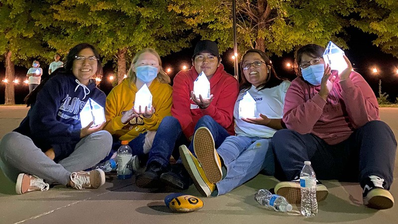 Utah State University students hold lanterns shaped like the top of Old Main's tower.
